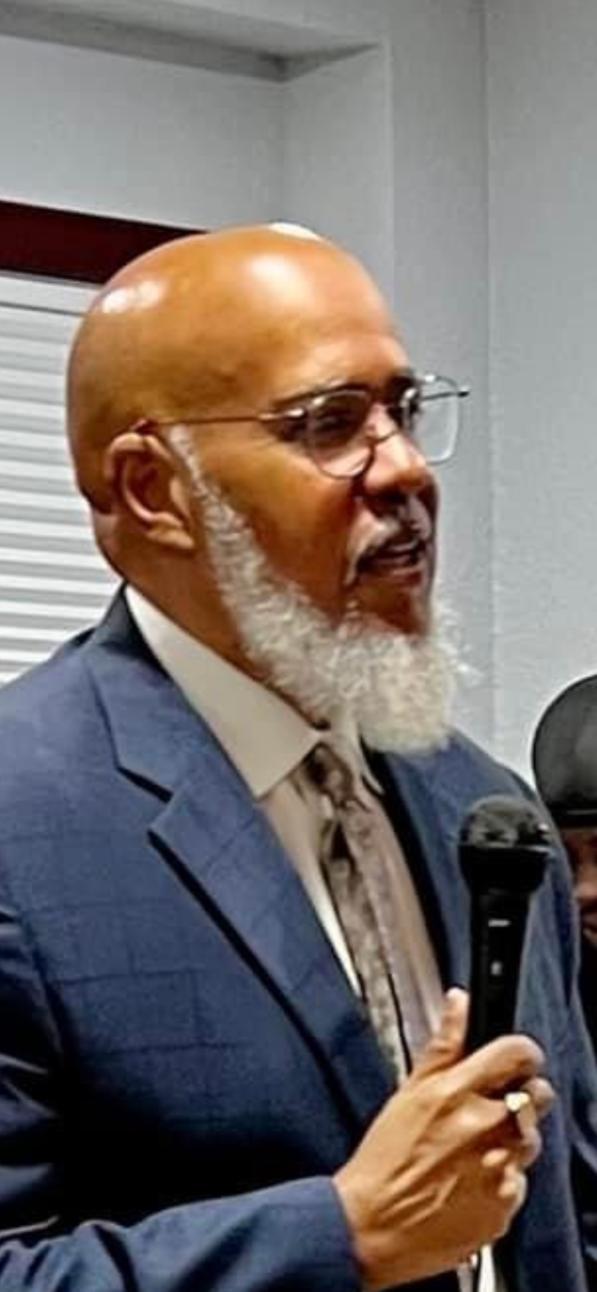 Minister speaking while holding a microphone